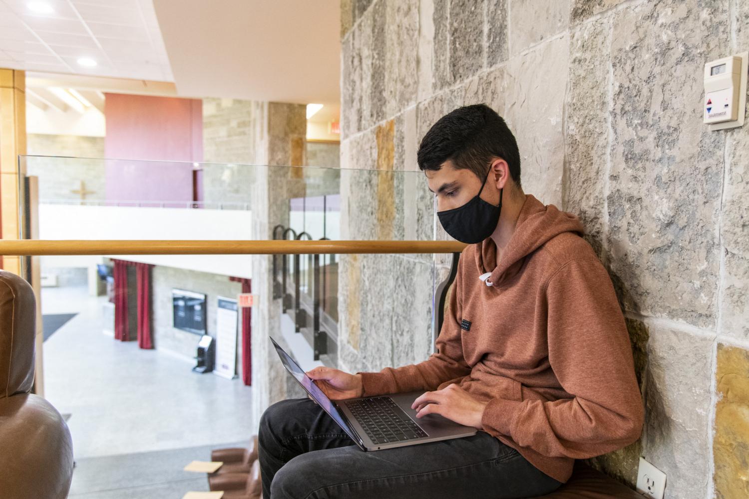A student takes a study break between classes on the second floor of the Clausen Center.