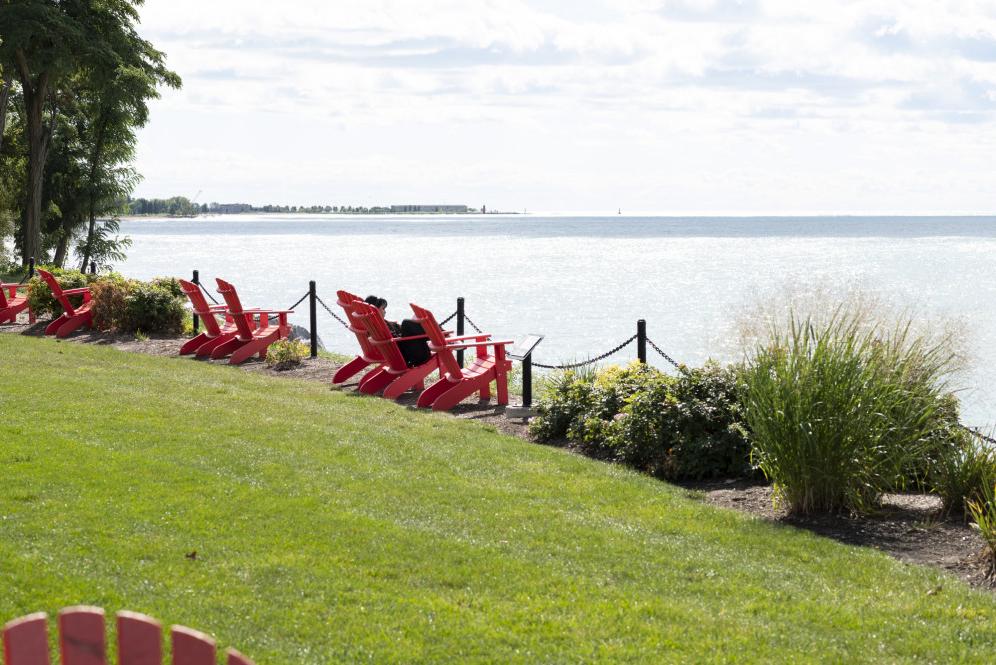 一名学生在密歇根湖边的一把红椅子上休息.