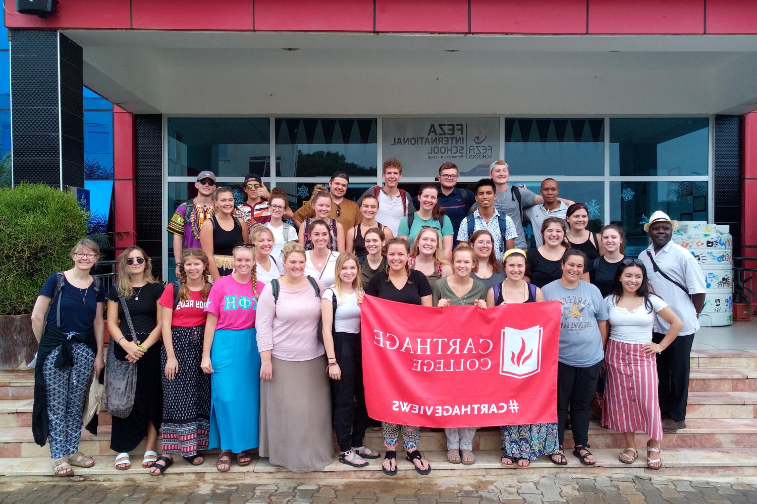 A group photo of students in front of FEZA International School on the study tour to Tanzania.
